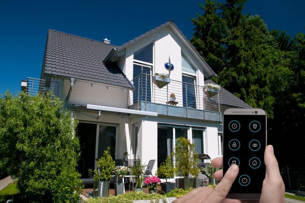 Modern house with a person using a smartphone to control home settings remotely